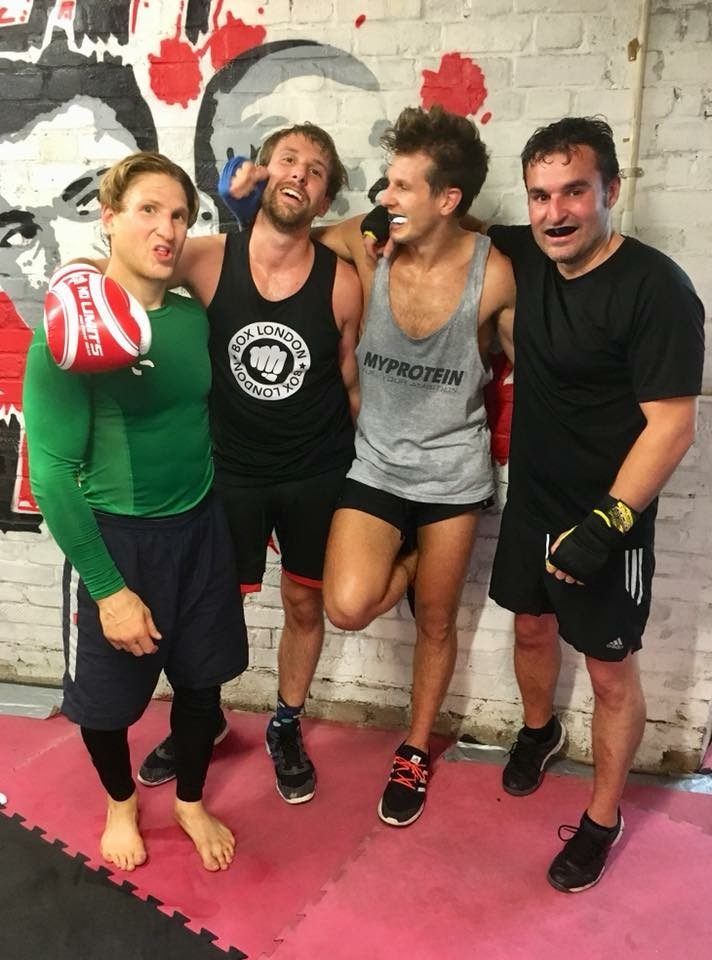 Four private student pose together with arms across shoulders after training